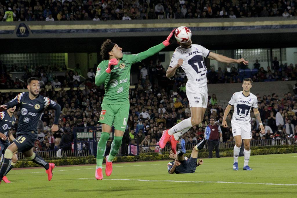 Guillermo Ochoa peleando un balón aéreo con Carlos Gonález