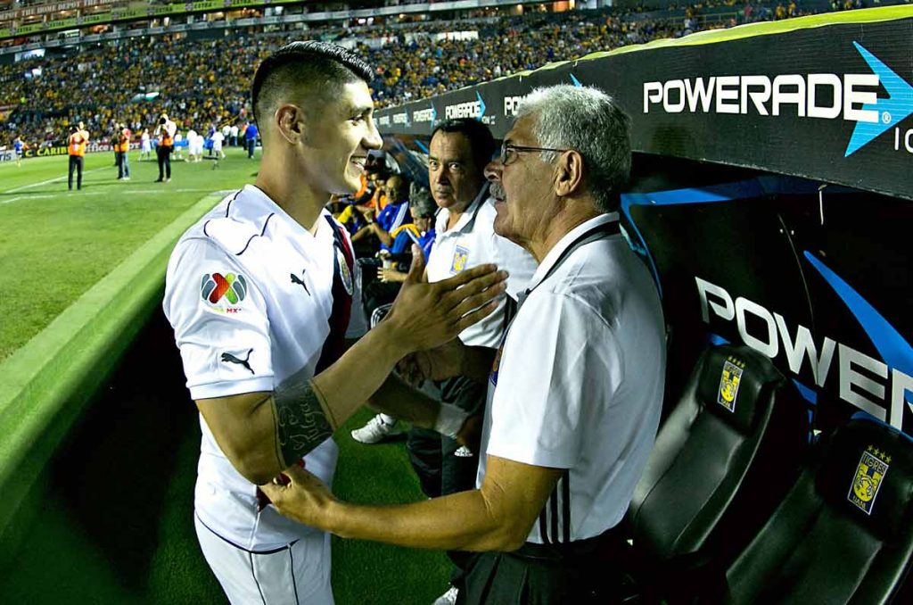 Alan Pulido y Tuca Ferretti se saludan durante un partido de Liga MX